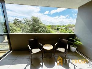 d'un balcon avec trois chaises et une table. dans l'établissement Lavish in Lyneham - 2BD 1Bth Apt, à Canberra 4 autres photos