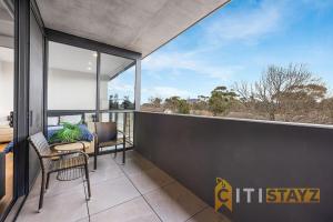 - un balcon avec deux chaises et une table dans l'établissement Lavish in Lyneham - 2BD 1Bth Apt, à Canberra