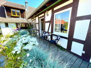 a porch of a house with two chairs and flowers at Apartment Bärbel by Interhome in Suhl