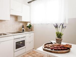 アスコナにあるApartment Junior Suite-7 by Interhomeの白いキッチン(カウンターに食料品のトレイ付)