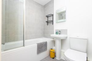a white bathroom with a tub and a sink and a toilet at Carnforth 91 by Alt-Stay - Wakefield 2 Bed Ensuite Townhouse Contractor and Corporate Accommodation with Private Parking, Smart TV, Kitchen and Fast Wi Fi - Long Stay Ready with Weekly and Monthly Rates in Wakefield