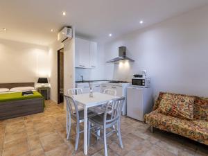 eine Küche und ein Wohnzimmer mit einem Tisch und einer Couch in der Unterkunft Holiday Home Villa 20 by Interhome in SantʼAmanza