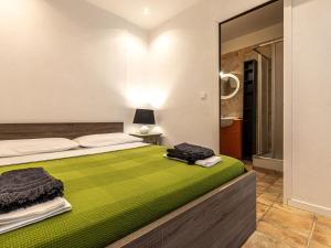 ein Schlafzimmer mit einem Bett mit einer grünen Decke in der Unterkunft Holiday Home Villa 20 by Interhome in SantʼAmanza