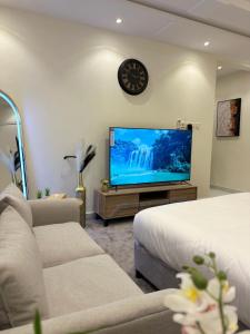 a living room with a large tv and a bed at شقق وأستوديوهات فخمة Skyline luxurious Apartments and Studios Riyadh in Riyadh