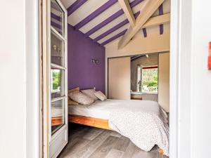 a bedroom with purple walls and a bed at Holiday Home OLHAKO BIDEA by Interhome in Amotz