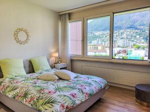 een slaapkamer met een bed en uitzicht op de stad bij Apartment Apt-Green View by Interhome in Locarno