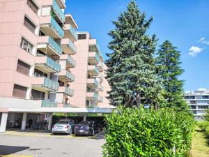 een groot appartementencomplex met auto's voor het gebouw bij Apartment Apt-Green View by Interhome in Locarno