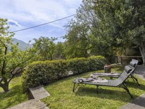 a garden with a chair and a table in the grass at Holiday Home Rosa by Interhome in Agarone