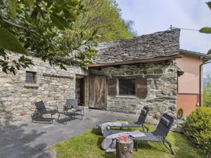 a stone house with two chairs and a patio at Holiday Home Rosa by Interhome in Agarone