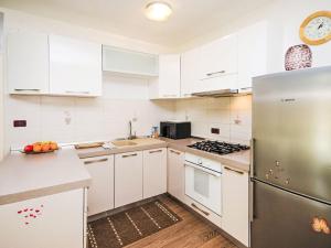 Una cocina con gabinetes blancos y un refrigerador de acero inoxidable. en Holiday Home Marlen by Interhome, en Rovinjsko Selo 8 fotos más
