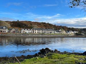 un gruppo di case sulla riva di un corpo idrico di Inverpod a Lochinver Altre 52 foto