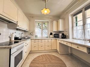 a large kitchen with white cabinets and a window at Holiday Home Großmutters Ferienhaus by Interhome in Mörbisch am See