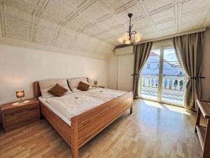 a bedroom with a bed and a large window at Holiday Home Großmutters Ferienhaus by Interhome in Mörbisch am See