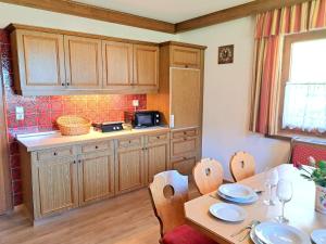 a kitchen with a table and a kitchenasteryasteryasteryasteryasteryasteryasteryastery at Holiday Home Gernkogel by Interhome in Vorderkrimml