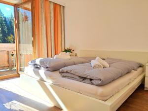 a bed in a room with a large window at Holiday Home Gernkogel by Interhome in Vorderkrimml
