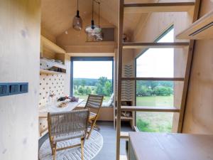 a tiny house with a large window and a table and chairs at Chalet Glamping Sokolka by Interhome in Branžež