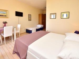 a hotel room with a bed and a table with a chair at Apartment Melandura-6 by Interhome in Dinjiška