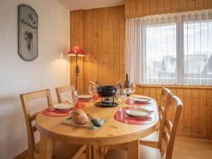 a dining room table with chairs and a wooden tableablish at Apartment Sources 4110 by Interhome in Ovronnaz