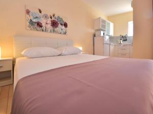 Cet appartement comprend une chambre avec un lit blanc et une cuisine. dans l'établissement Apartment Melandura-2 by Interhome, à Dinjiška 24 autres photos