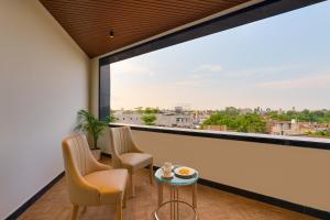 a balcony with two chairs and a table and a large window at Lemon Tree Hotel, Motihari in Motīhāri