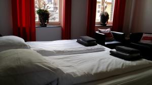 een slaapkamer met 2 bedden, een bank en ramen bij De Roermondse beleving in Roermond