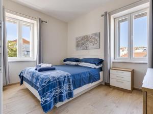 a bedroom with a bed and two windows at Holiday Home Ivanica by Interhome in Zablaće