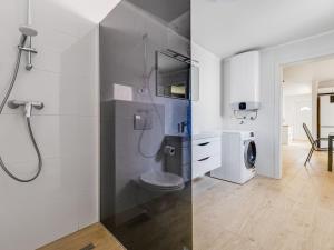 a bathroom with a shower with a toilet and a washing machine at Holiday Home Ivanica by Interhome in Zablaće