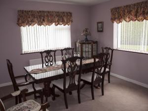 a dining room with a table and chairs and two windows at Holiday Home Eagle View Holiday Home by Interhome in Moone +7 photos