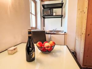 a bottle of wine and a bowl of fruit on a table at Apartment Cheeky Apartment-1 by Interhome in Oberndorf in Tirol
