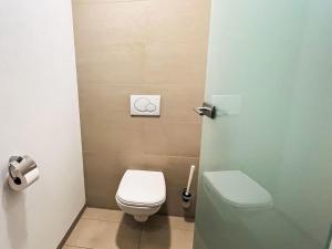 a small bathroom with a toilet and a door at Apartment Cheeky Apartment-1 by Interhome in Oberndorf in Tirol