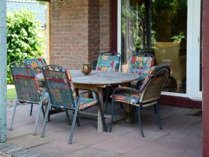a wooden table and chairs on a patio at Holiday Home Zedernhütte by Interhome in Bremke