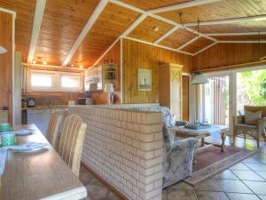 a kitchen and living room with a table and chairs at Holiday Home Zedernhütte by Interhome in Bremke