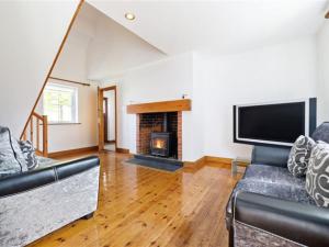 un salon avec un canapé et une cheminée dans l'établissement Holiday Home Brittas Bay Holiday Village No 7 by Interhome, à Brittas Bay
