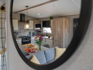 a view of a kitchen with a table in a mirror at Chalet Lodge 15 by Interhome in Boat of Garten +18 photos