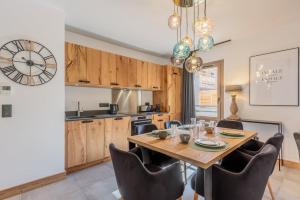 a kitchen and dining room with a wooden table and chairs at Blanchets, Terrasse et confort 4 étoiles in Champagny-en-Vanoise