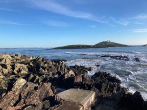 Apartment Ballycotton Holiday - TR1-2 Apartment No 6 by Interhome في بوليكوتون: إطلالة على المحيط مع صخور في الماء