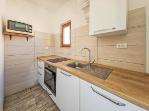 eine kleine Küche mit Spüle und Mikrowelle in der Unterkunft Holiday Home Palada by Interhome in Marina
