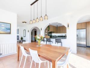a dining room and kitchen with a wooden table and chairs at Holiday Home Belle vue by Interhome in Palau-Saverdera