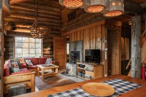 a living room in a log cabin with a table at Villa Tunturituuli in Kuusamo