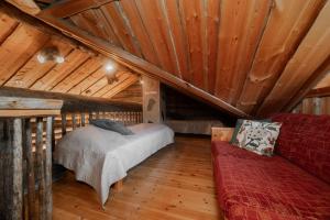 a bedroom with a bed and a couch in a attic at Villa Tunturituuli in Kuusamo