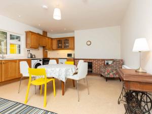 a kitchen with a table and yellow chairs in a room at Holiday Home An Searrach Holiday Home Dingle by Interhome in Dingle