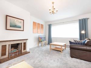 a living room with a couch and a fireplace at Holiday Home An Searrach Holiday Home Dingle by Interhome in Dingle