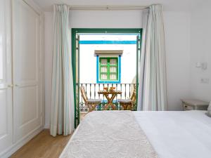 a bedroom with a bed and a balcony with a table at Marina nº 296 in Puerto de Mogán +45 photos