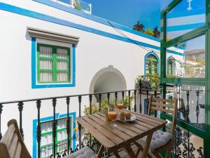 a balcony with a wooden table and chairs at Marina nº 296 in Puerto de Mogán