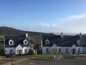 una casa blanca con techo negro en Holiday Home Bayview Holiday Home No 39 by Interhome, en Dunmore East