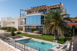 a villa with a swimming pool and a house at Bonaventura Residence in Murter