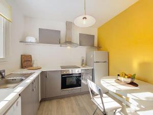 a kitchen with a sink and a table and a refrigerator at Holiday Home Les Floriales by Interhome in Vaux-sur-Mer