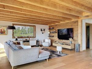 a living room with a couch and a tv at Chalet Chalet ECO by Interhome in Thyez +49 photos