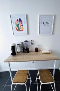 a wooden desk with two stools in a room at Charme et Douceur By UTA HOUSE in Saint-Denis