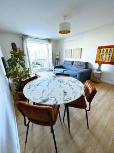 a living room with a table and chairs and a couch at Charme et Douceur By UTA HOUSE in Saint-Denis